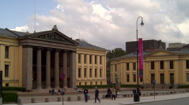 Main building of the University of Oslo with neoclassical architecture and surrounding greenery.

