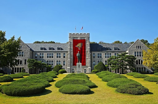 Front view of Korea University’s majestic stone buildings and green campus, symbolizing academic excellence in South Korea